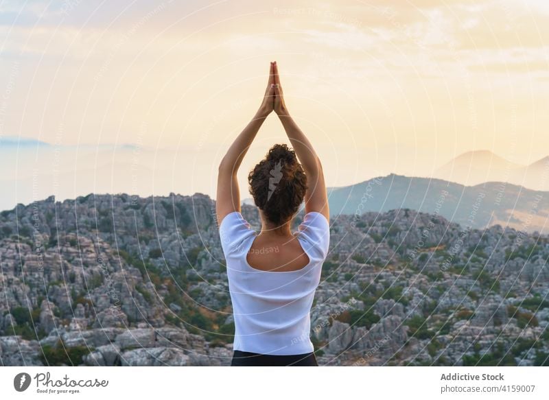 Konzentrierte Frau übt Yoga in den Bergen bei Sonnenuntergang Berge u. Gebirge Stern rückwärts Gebetshände Felsen Natur üben Asana Pose positionieren Wellness