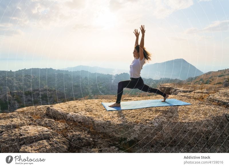Konzentrierte Frau übt Yoga in den Bergen bei Sonnenuntergang Berge u. Gebirge Felsen Natur üben Asana Pose positionieren Wellness Harmonie Gleichgewicht