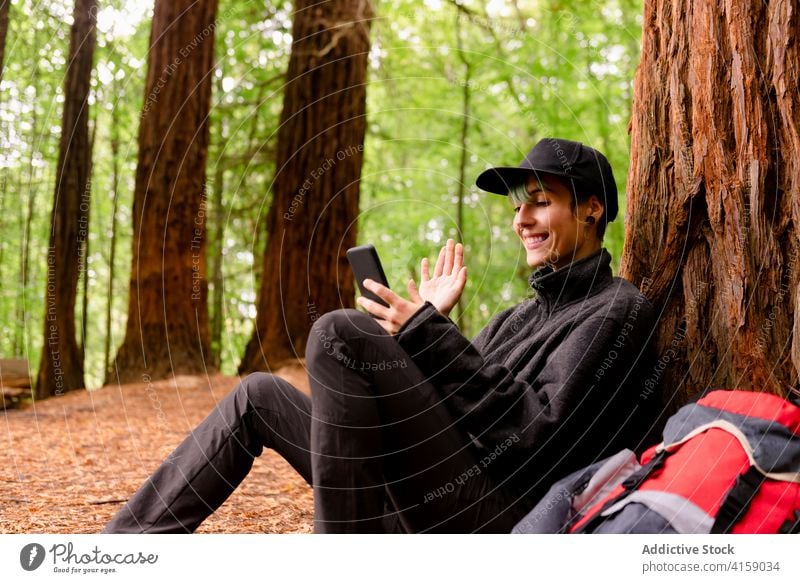 Lächelnder Reisender im Gespräch über Video-Chat im Wald Videoanruf Frau Smartphone erkunden Wälder Wellenhand Gruß monte cabezon naturdenkmal der sequoias