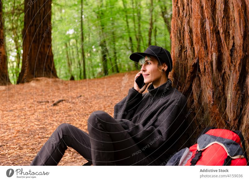 Lächelnder Reisender telefoniert im Wald Frau sprechend Smartphone erkunden Wälder Gruß Naturdenkmal der Mammutbäume Kantabrien Spanien Anruf Baum Tourist