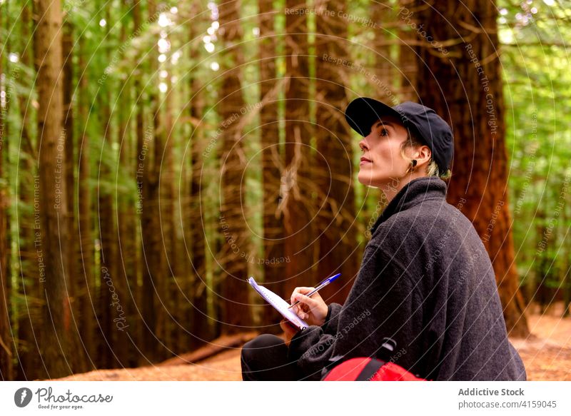 Reisende Frau macht sich Notizen in einem Notizbuch im Wald Entdecker Wälder Notebook zur Kenntnis nehmen Ausflugsziel Tourist Baum Kantabrien