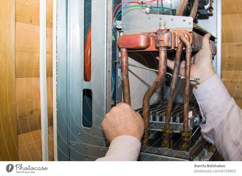 Arbeiter montiert den Wärmetauscher nach der Entkalkung an einem Arbeitsplatz in der Gastherme einstellbar Erwachsener Vorrichtung Keller Heizkessel Business