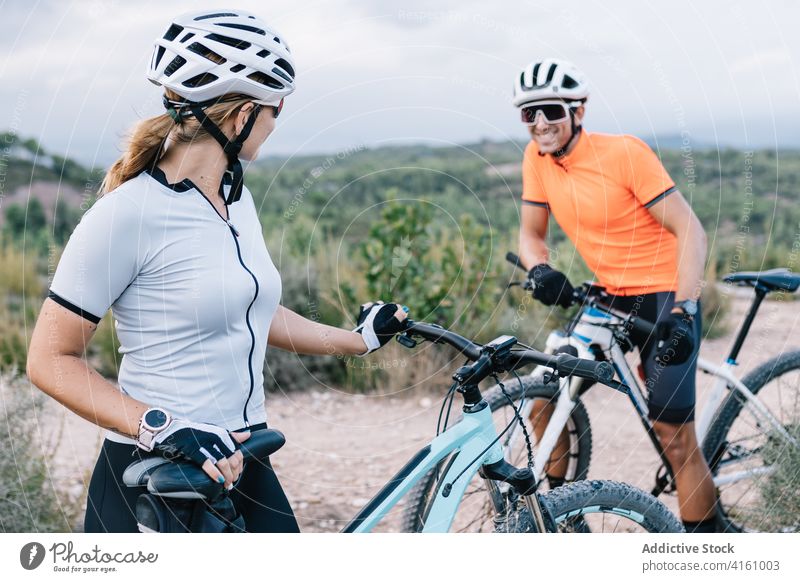 Ein Paar Radfahrer mit Fahrrädern in der Natur Reiter heiter Zusammensein Fahrrad Verkehr passen Sonnenbrille Schutzhelm behüten Handschuh extrem modern jung