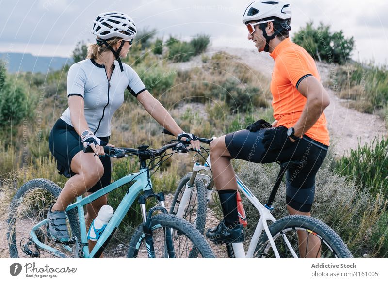 Ein Paar Radfahrer mit Fahrrädern in der Natur Reiter heiter Zusammensein Fahrrad Verkehr passen Sonnenbrille Schutzhelm behüten Handschuh extrem modern jung