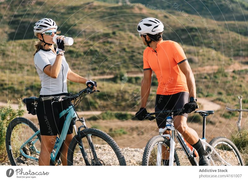 Radfahrer entspannen sich bei einer Fahrt in den Bergen Fahrrad Paar Berge u. Gebirge Zusammensein Sport Pause Training trinken Wasser Hochland Gegend ruhen