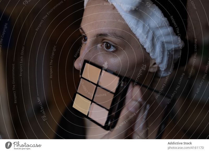 Konzentrierte Frau bei der Vorbereitung zum Auftragen von Puder Model Pulver bewerben vorbereiten Stirnband Palette Kosmetik Make-up Konzentration Überarbeitung