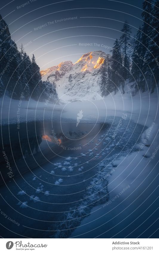 Eisiger Teich spiegelt verschneiten Berg in der Nähe von Bäumen im Winter Berge u. Gebirge Schnee Reflexion & Spiegelung Natur Hochland Baum Himmel Einsamkeit