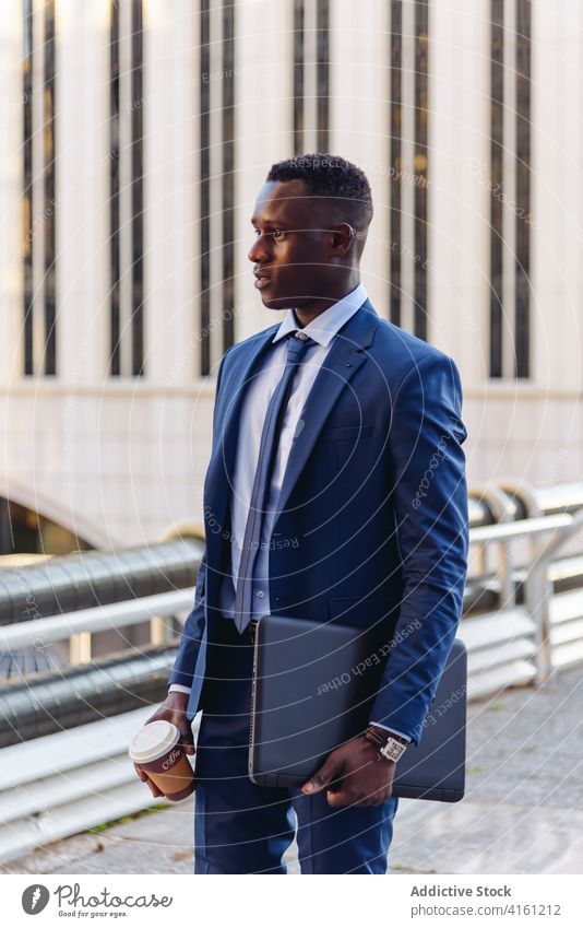 Stilvoller schwarzer Mann im Anzug geht in der Innenstadt spazieren Geschäftsmann selbstbewusst Exekutive formal Stadtzentrum urban respektabel modern Erfolg