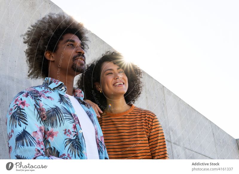 Multiethnische Freunde in stilvoller Kleidung in der Nähe einer Zementmauer Paar stylisch Bekleidung Frisur Afro-Look achtsam Freundschaft Wand Porträt