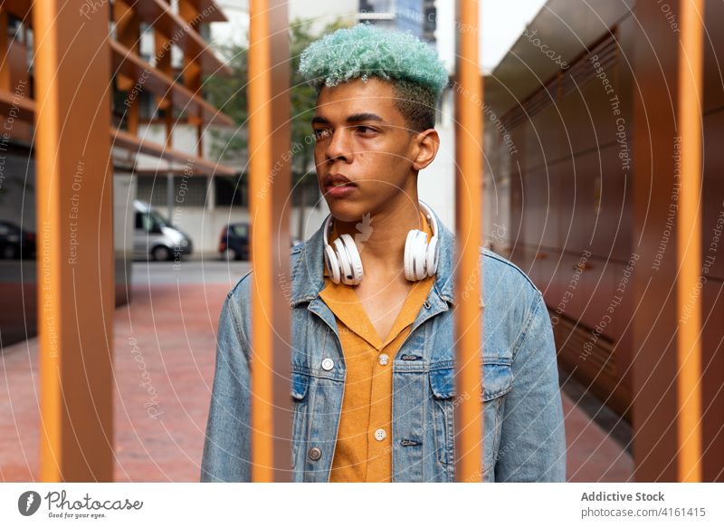 Nachdenklicher ethnischer Mann mit blauem Haar in der Stadt blaue Haare Hipster Straße Stil Generation jung gefärbtes Haar Vorschein gutaussehend männlich