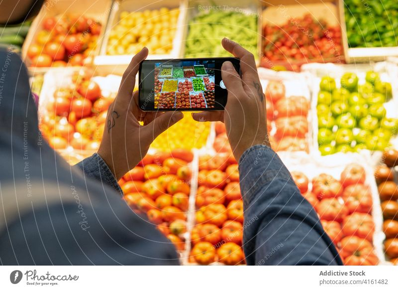 Kunde fotografiert Lebensmittel mit seinem Smartphone Lebensmittelgeschäft Gemüse fotografieren Markt Käufer Mobile Telefon Supermarkt Ware Produkt frisch