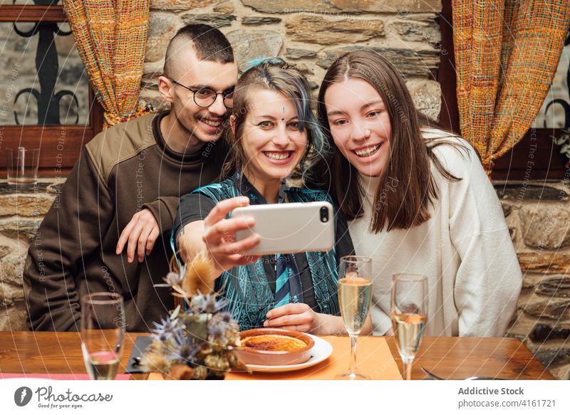 Fröhliche Freunde machen ein Selfie im Café Hipster Unternehmen Smartphone sich[Akk] sammeln Freundschaft Selbstportrait Spaß haben ausgefallen Vorschein Tisch