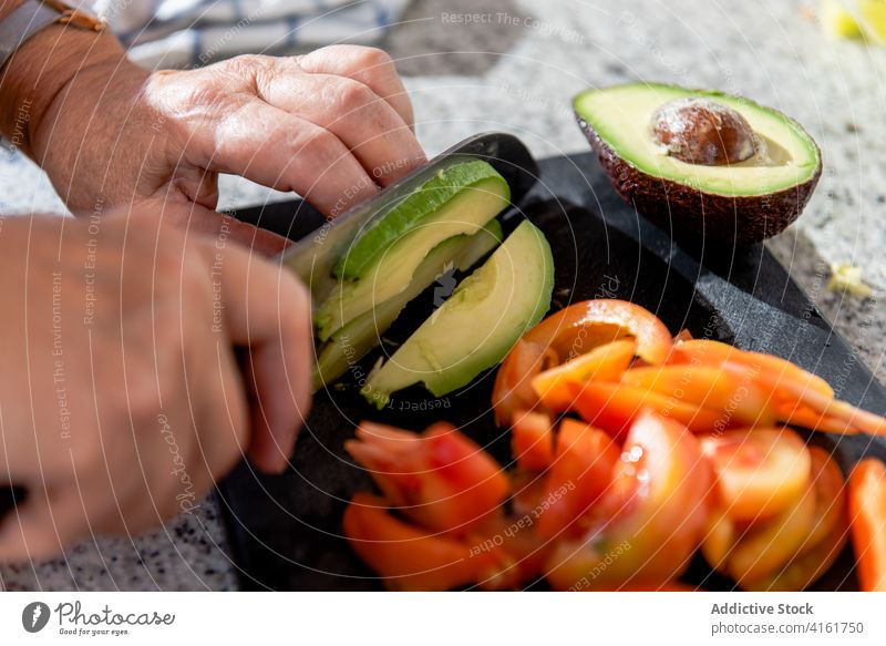 Crop reife Frau Schneiden Avocado auf dem Brett geschnitten Tomate Gemüse Koch kulinarisch Lebensmittel Prozess Gastronomie Rezept Küche Zeitgenosse Abendessen
