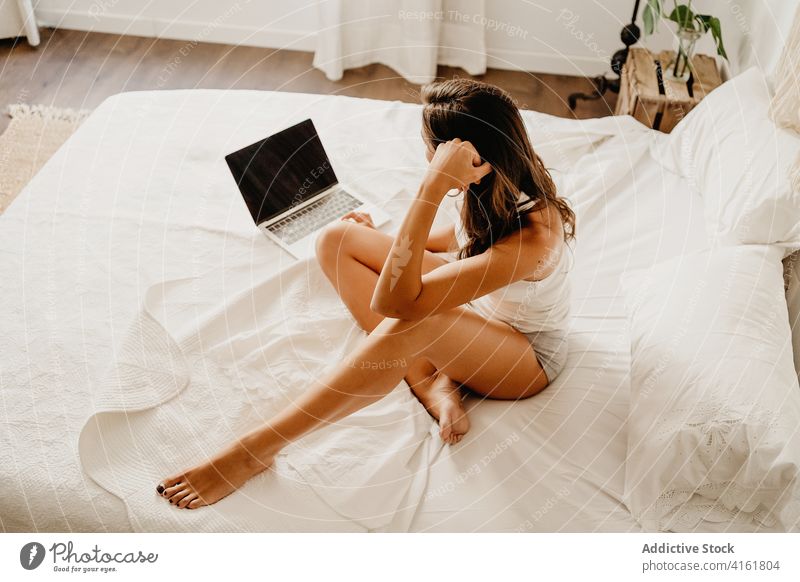 Frau mit Laptop im Bett Morgen Lächeln benutzend Glück Browsen Schlafzimmer heimwärts jung Gerät Apparatur Internet gemütlich online Freude wach Kommunizieren