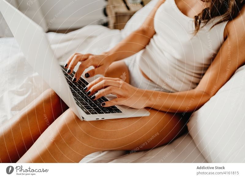 Anonyme Frau mit Laptop im Bett Morgen Lächeln benutzend Glück Browsen Schlafzimmer heimwärts jung Gerät Apparatur Internet gemütlich online Freude wach