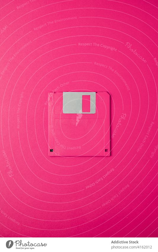 Computer-Diskette auf rosa Hintergrund Floppy Lamelle alt pc altmodisch Information Daten veraltet Gerät Werkzeug altehrwürdig retro Accessoire sehr wenige