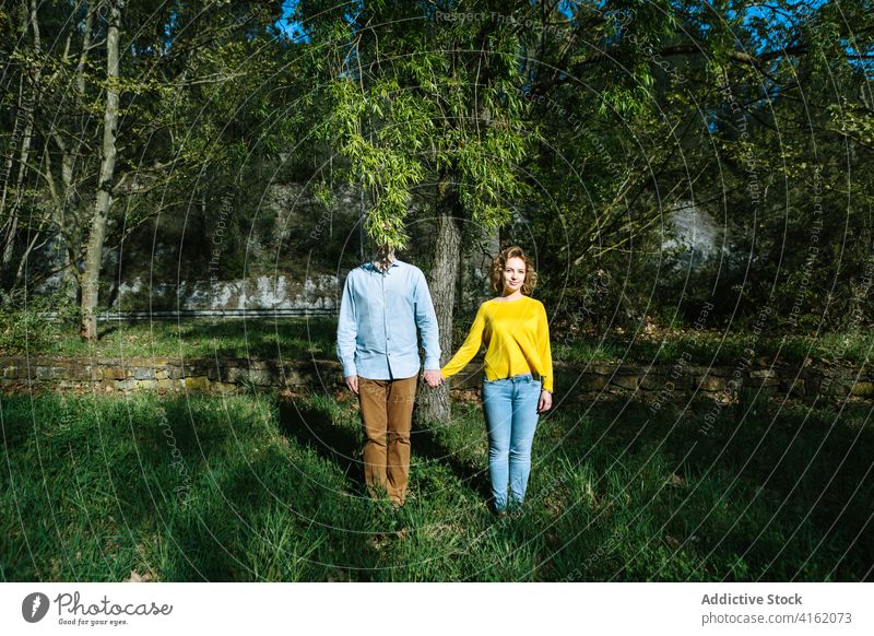 Paar steht zusammen im Park Händchenhalten Windstille Zusammensein Baum Deckblatt romantisch Sommer Sonnenlicht Freund Freundin Partnerschaft kreativ merkwürdig