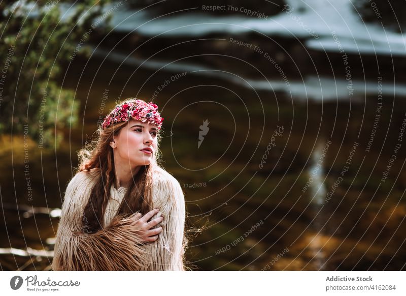 Junge Frau in Boho-Outfit zu Fuß in der Nähe von Fluss im Frühling Wald nordisch Tradition Mode Stil Fell skandinavisch charmant hochzeitlich jung Kleid Natur