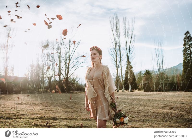 Romantische Frau mit Blumenstrauß bei einem Spaziergang in der herbstlichen Landschaft romantisch Braut Boho Herbst verträumt Stil besinnlich jung Bohemien