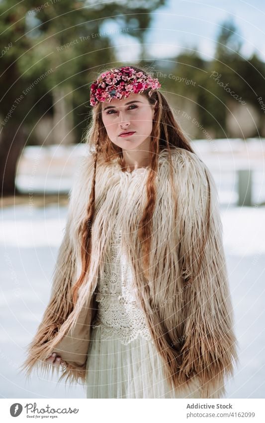 Nordische Braut in Pelzmantel auf verschneiter Wiese stehend Frau Mode nordisch Hochzeit Fell Schnee Stil Natur Wald Totenkranz Saison blond Winter Frühling