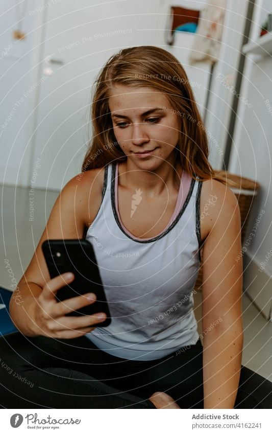 Zufriedene Sportlerin auf dem Smartphone Selfie Vitalität Energie Training Lächeln Inhalt üben zu Hause Aktivität physisch Sportbekleidung Fotografie Frau