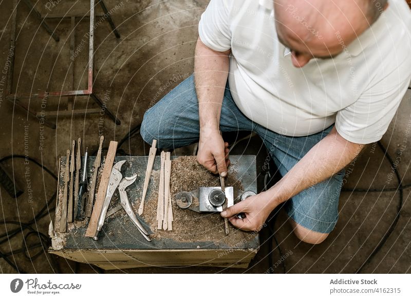 Unbekannter männlicher Holzarbeiter bei der Arbeit in der Garage Grinden Schreinerei Werkstatt Mann Zimmerer Tischlerin Holzarbeiten Pferch Ventilator