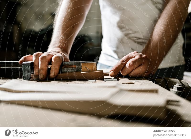 Männlicher Schreiner bei der Arbeit mit Holz in der Garage Tischlerin Werkstatt Mann Holzarbeiten Zimmerer Schreinerei Detailaufnahme alt Hobelbank Industrie