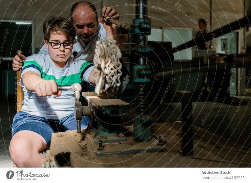 Junge hilft Vater in schmuddeliger Werkstatt Grunge Sohn polnisch Hilfsbereitschaft Zusammensein Helfer Fokus Konzentration beschäftigt Arbeit Presse Basteln