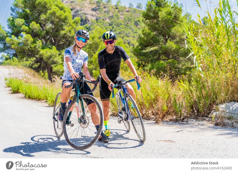 Ein Paar Radfahrer schaut in die Kamera Fahrrad Mitfahrgelegenheit Berge u. Gebirge Glück aktiv Lächeln Natur Sport Lifestyle Aktivität in die Kamera schauen
