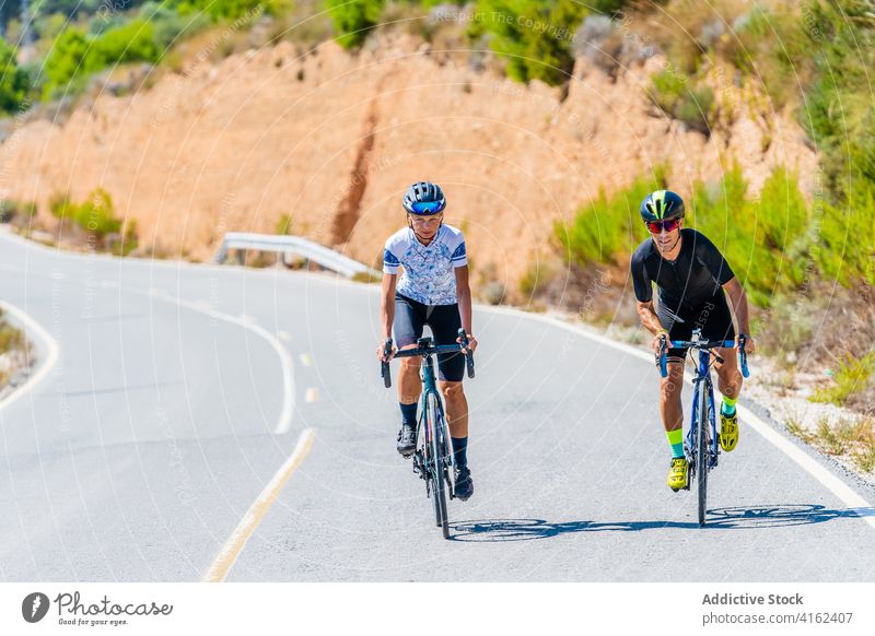 Aktives Paar fährt mit dem Fahrrad auf einer Landstraße Radfahrer Mitfahrgelegenheit Straße Zeigen Sie weg aktiv Zusammensein Natur Lifestyle Sport Aktivität