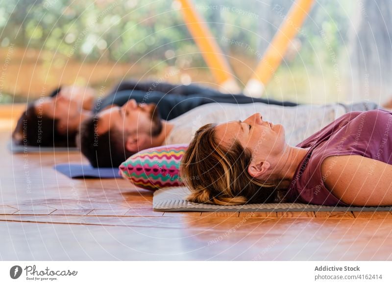 Menschen in Shavasana-Pose auf Yogamatten shavasana sich[Akk] entspannen Augen geschlossen meditieren Zen friedlich Harmonie Klasse Lügen Stock reflektierend