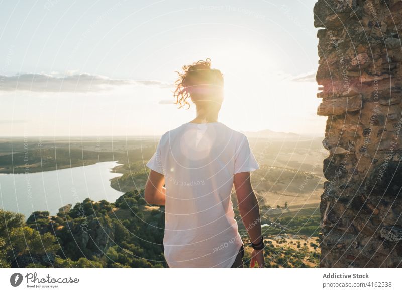 Unbekannter Mann steht auf einem Hügel über einem sonnigen Tal malerisch bewundern Natur Teich Grün Aussichtspunkt Landschaft Bergkuppe Fernweh reisen