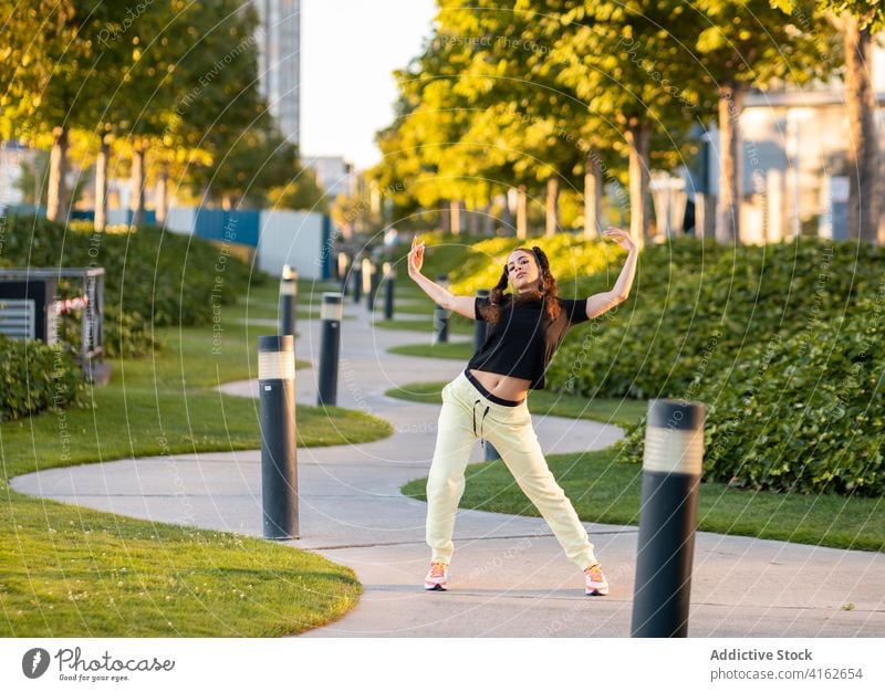 Flexible junge Frau tanzt im Park Tanzen Weg aktiv Ballerina trendy beweglich Großstadt sich[Akk] bewegen Energie cool Hobby Stil Outfit Frisur Turnschuh modern