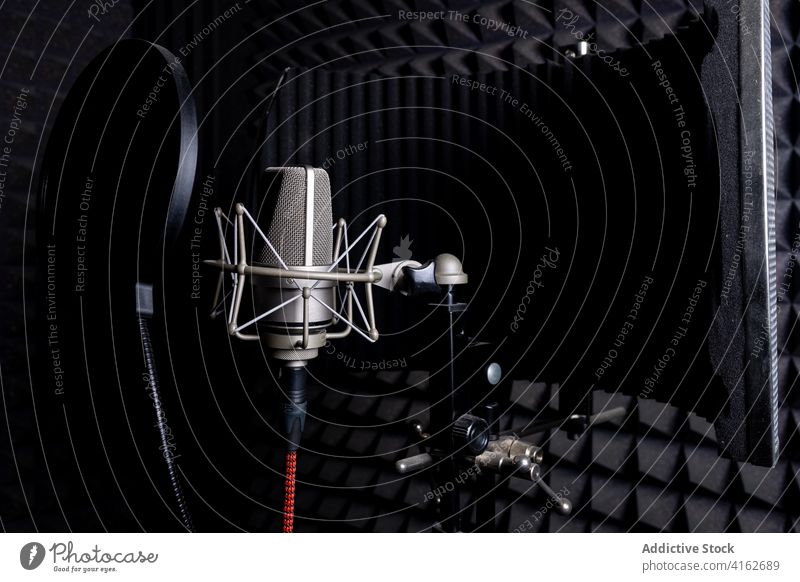 Modernes Mikrofon im dunklen Studio Aufzeichnen Atelier Musik schalldicht schäumen Gerät dunkel modern Klang Audio professionell Apparatur Gesang Melodie