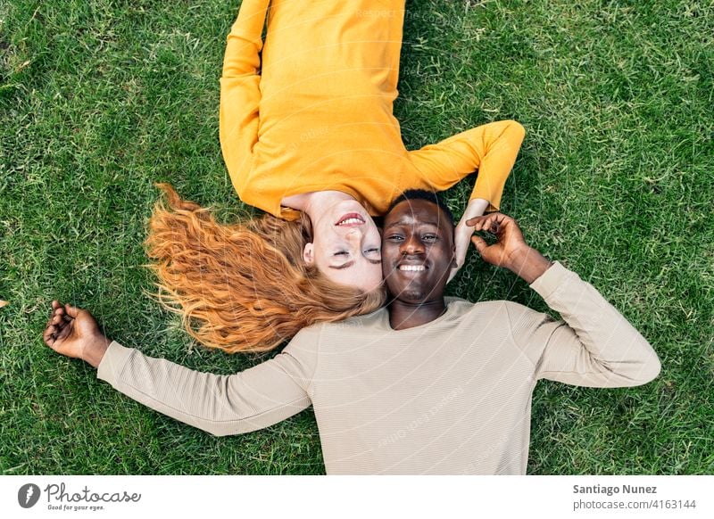 Multiethnische Paar Kuscheln im Gras Lügen Spaß haben Draufsicht Porträt Partnerschaft multirassisch Schwarzer Mann Kaukasier multikulturell multiethnisch