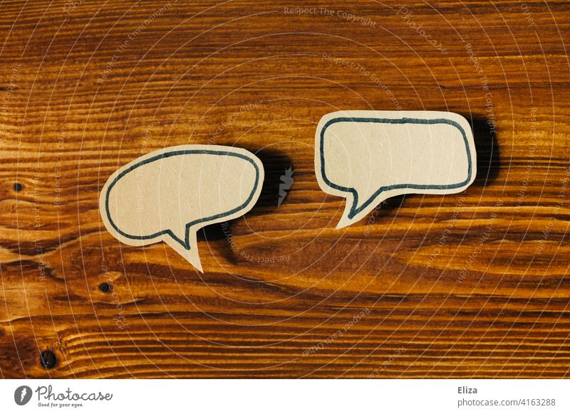 Zwei leere Sprechblasen auf Holz. Kommunikation, reden und Gespräch. zwei Dialog sprechen Kommunizieren diskutieren Diskussion Austausch