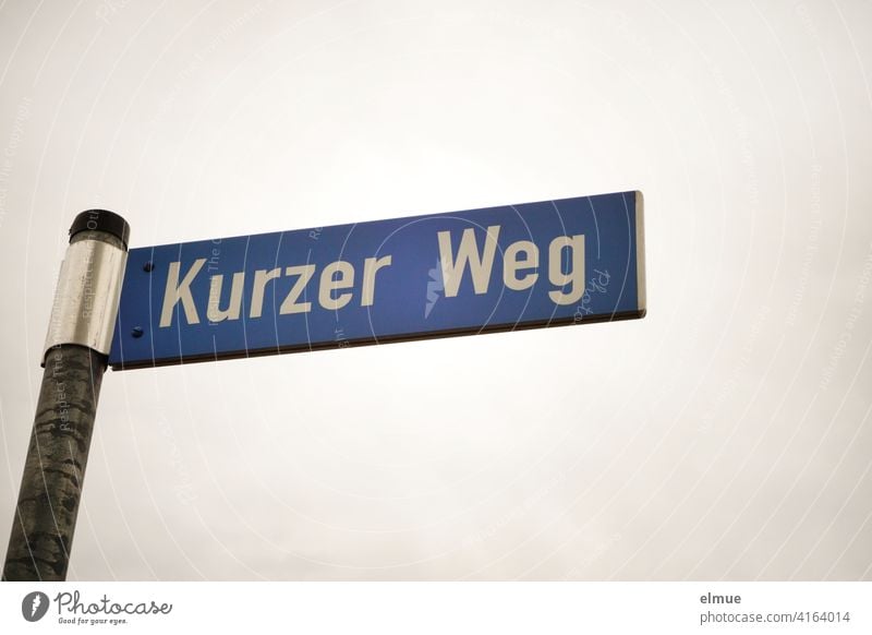 blaues Straßenschild " Kurzer Weg " an einer Eisenstange / Straßenname / wohnen / Bürokratie kurzer Weg einfach symbolisch langer Weg Strecke Schild Hinweis