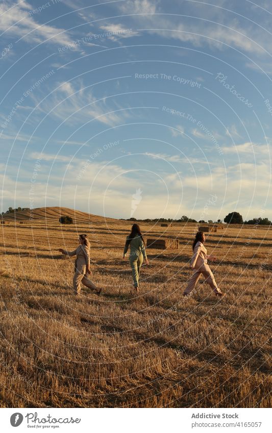 Anonyme Frauen, die auf einem Feld auf dem Lande spazieren gehen Spaziergang Landschaft trendy Regie Wiese Stil Zeit verbringen Natur sich[Akk] entspannen