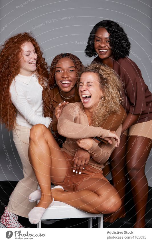 Gruppe von verschiedenen Frauen, die Spaß im Studio haben Lachen Freundschaft sich[Akk] sammeln Witz Spaß haben Atelier krause Haare Geflecht heiter