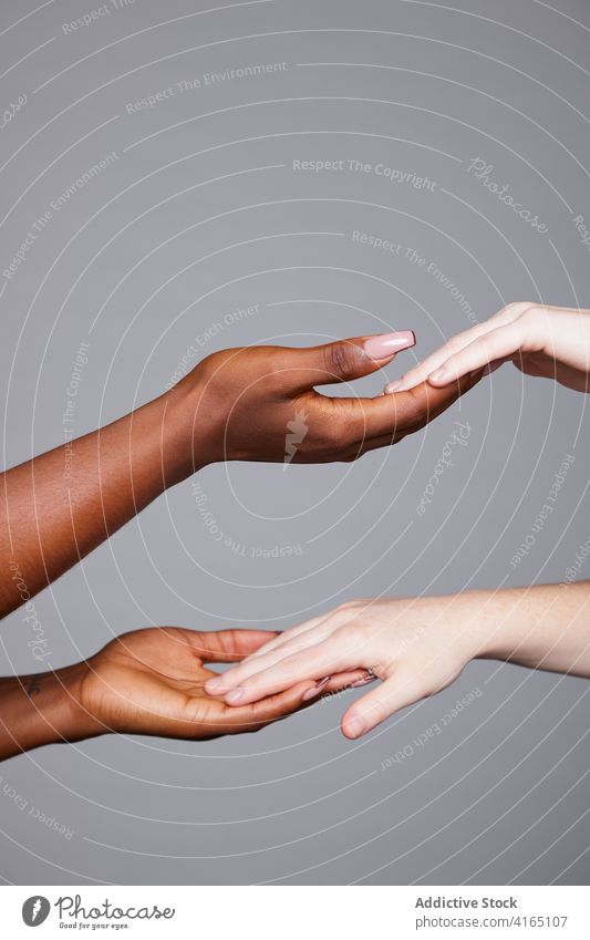 Multirassische Frauen berühren Hände im Studio gleich Rennen Gruß gestikulieren Angebot Freundschaft multiethnisch Konzept rassenübergreifend vielfältig