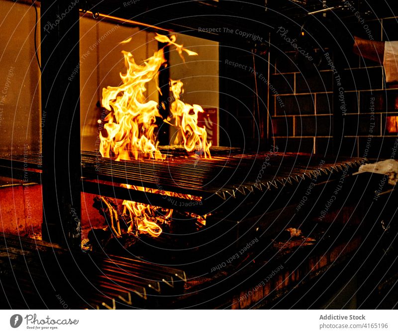 Flammender Holzkohlegrill in der Restaurantküche Grillrost Feuer Brandwunde Gerät Küche heiß Schmelzofen Barbecue professionell erwärmen Koch Herd Stahl
