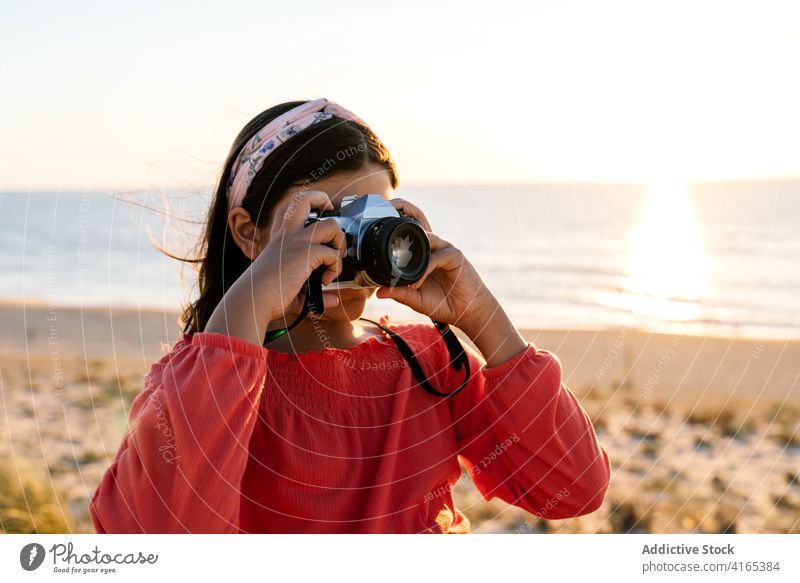 Unbekannter weiblicher Teenager fotografiert das Meer bei Sonnenuntergang Mädchen fotografieren MEER Strand reisen bewundern Feiertag Küste Sand Ufer Natur Stil