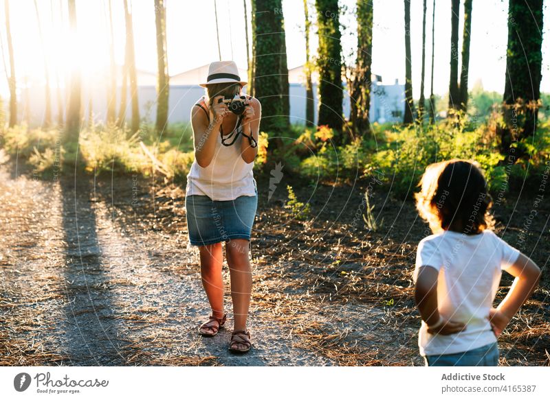 Anonyme Mutter, die einen kleinen Jungen im Wald an einem sonnigen Tag fotografiert Frau fotografieren Kind Park Natur Gasse Fotograf reisen Sohn Zusammensein