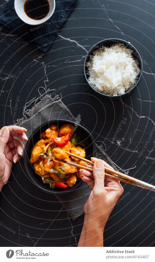 Gesichtslose Dame beim Abendessen mit Stäbchen in einem asiatischen Restaurant Frau Hähnchen Speise Asiatische Küche appetitlich lecker Mahlzeit Reis Sojasauce