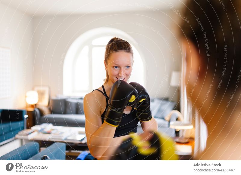 Sportlerinnen bereiten sich auf das Boxtraining zu Hause vor Boxsport Training vorbereiten Handschuh Fausthandschuh Gerät Personal Ausbilderin Trainer Kämpfer