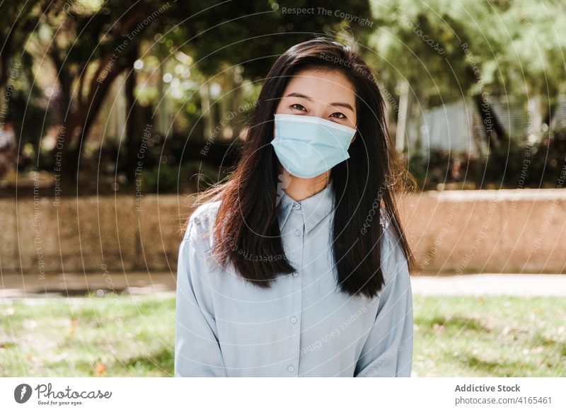 Junge asiatische Frau chillt im Park während des Coronavirus Kälte positiv elegant neue Normale sich[Akk] entspannen genießen Windstille formal Mode Natur jung
