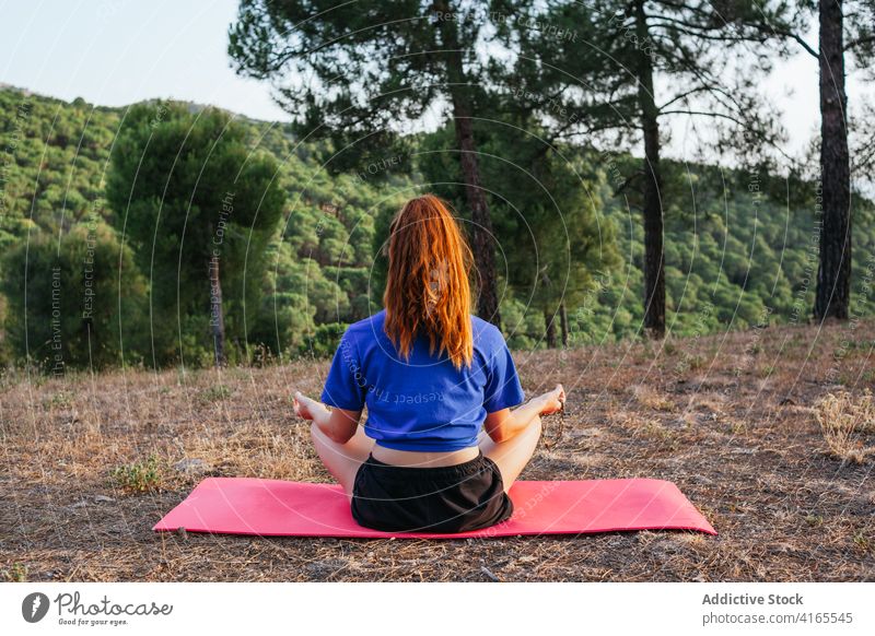 Ruhige Frau macht Yoga in Lotus-Pose meditieren Mudra Asana padmasana Wulst Unterlage Natur gestikulieren friedlich Zen ruhig Wellness Sonnenuntergang