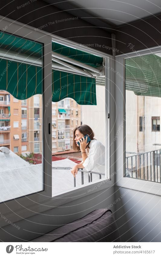 Junge Frau spricht auf dem Balkon mit ihrem Smartphone reden Gespräch Telefonanruf Kommunizieren diskutieren heimwärts sich[Akk] entspannen Anschluss Mobile