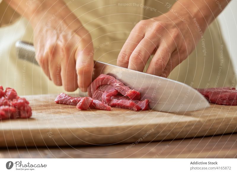Crop Frau Schneiden von Fleisch in der Küche geschnitten Rindfleisch Koch Steak Tartar Hausfrau vorbereiten Abendessen Speise Schneidebrett frisch hölzern