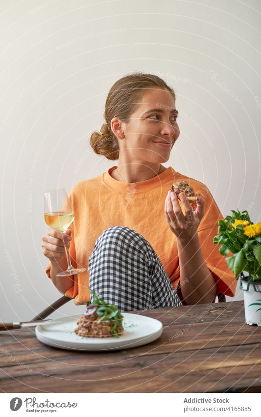 Lächelnde Frau beim leckeren Mittagessen zu Hause Steak Tartar heimwärts Wein trinken genießen Wochenende Speise Freude Teller Tisch ruhen Glück Feinschmecker